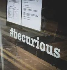hash tag be curious lettering on window