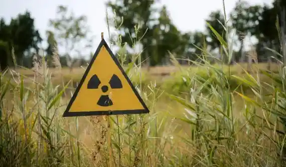 Radioactive sign outside in grass field